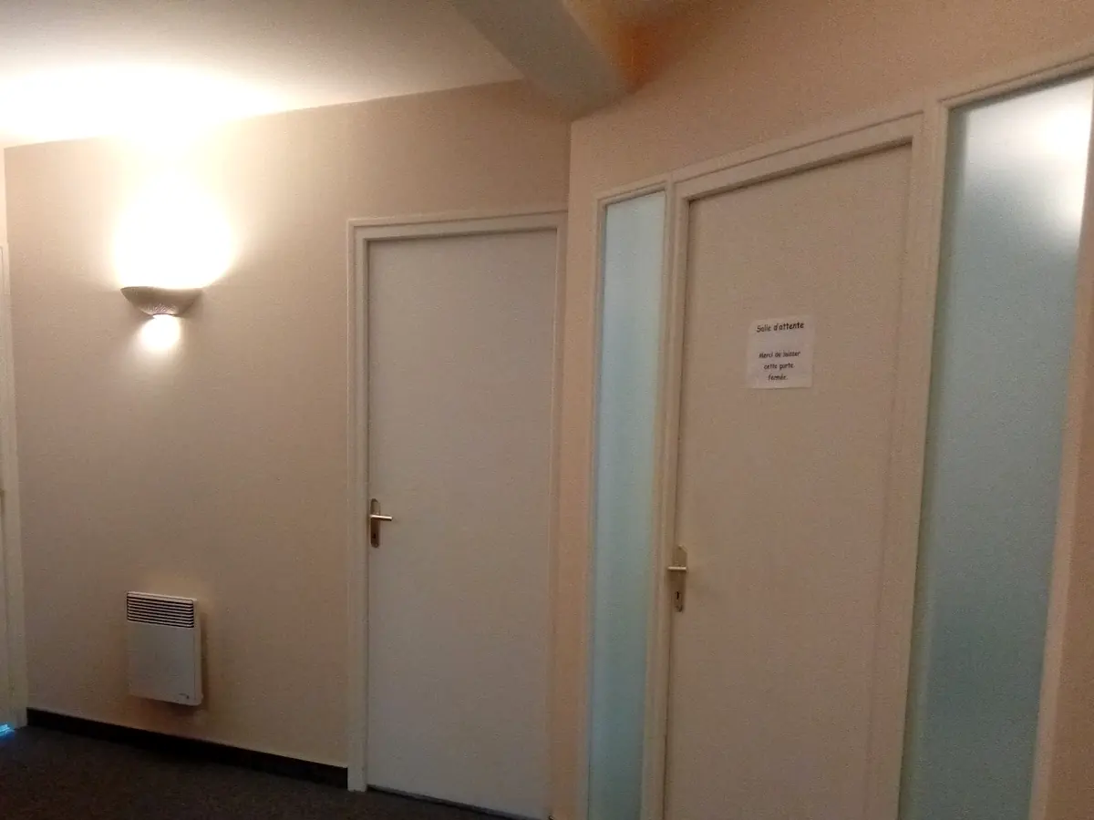 Le couloir du cabinet, sa lumière douce et la porte de la salle d'attente
